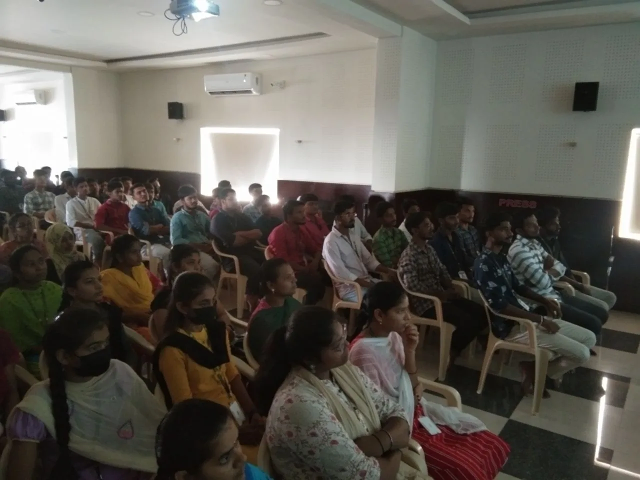 C Sarath Babu's writing on the Gain and Shine launch, 2023. Students in the audience during the presentation