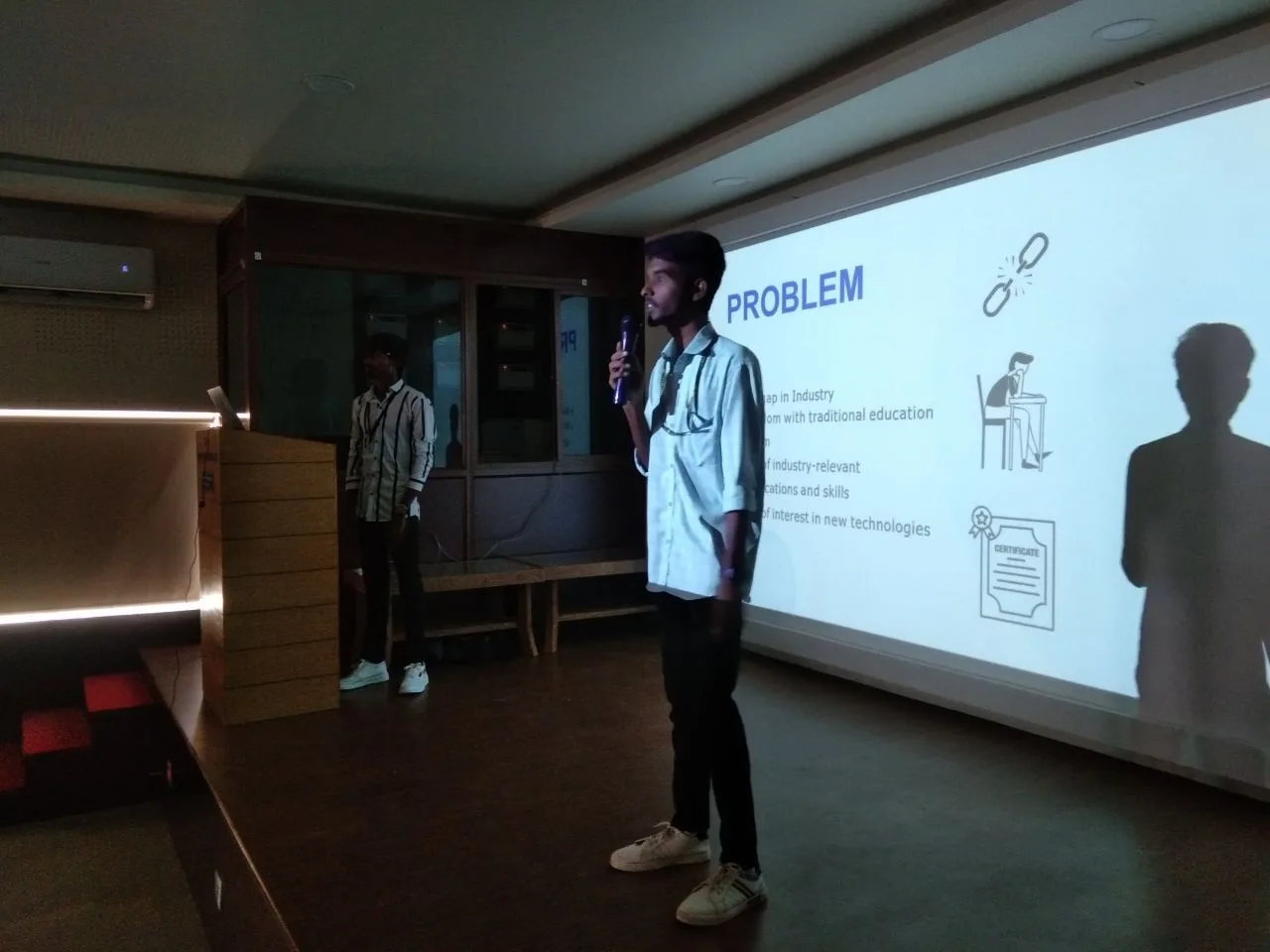 C Sarath Babu's writing on the Gain and Shine launch, 2023. Sarath presenting the problem slide with a microphone