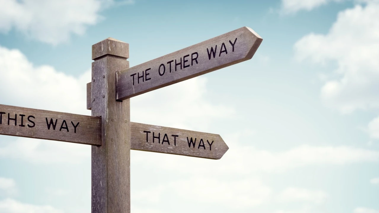 C Sarath Babu's writing on work and passion. A wooden signpost against a blue sky, its arms pointing three different ways