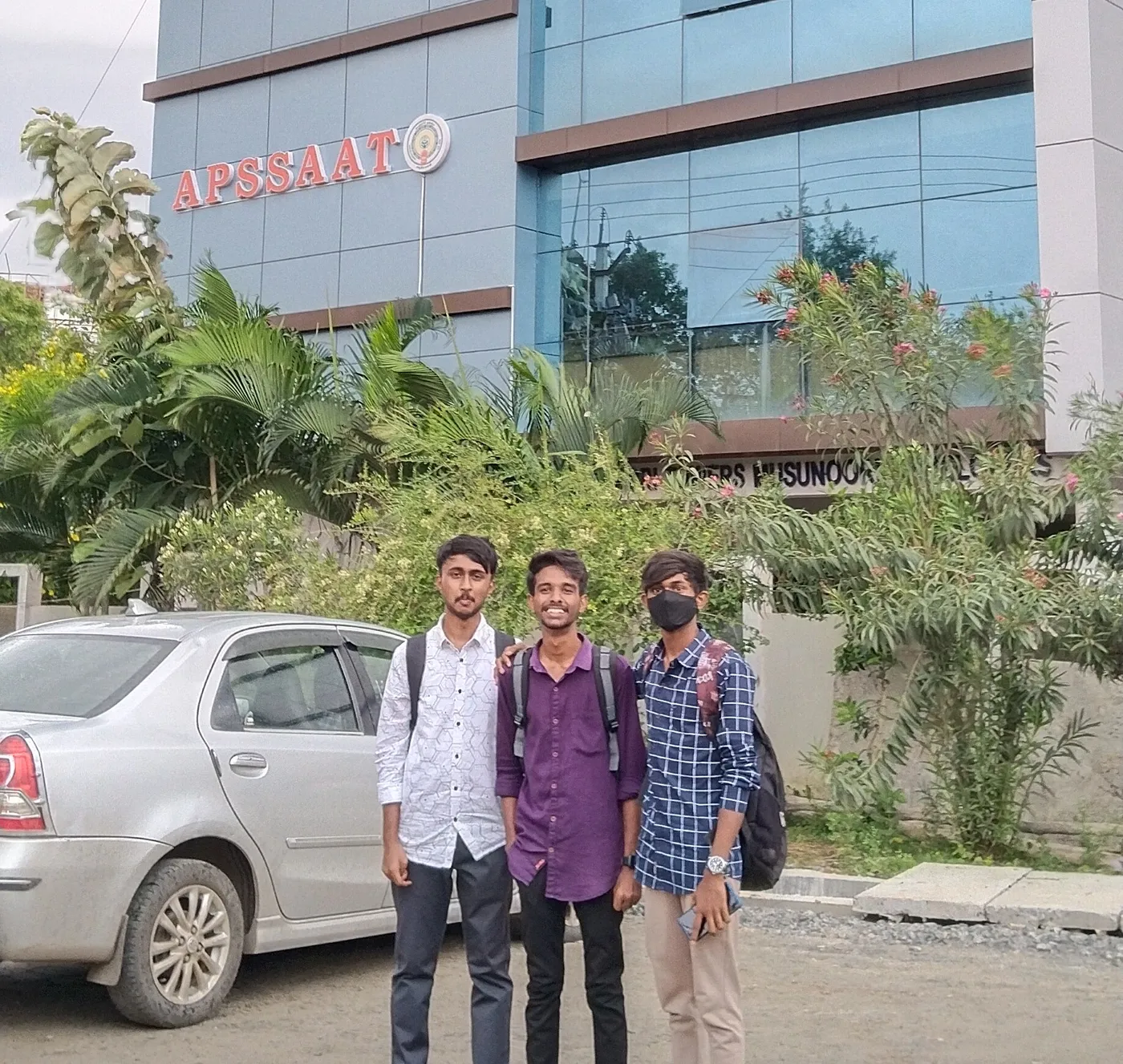 C Sarath Babu's writing on the APSCHE award, 2023. Sarath, Pavan and Parjan outside the APSSAAT building