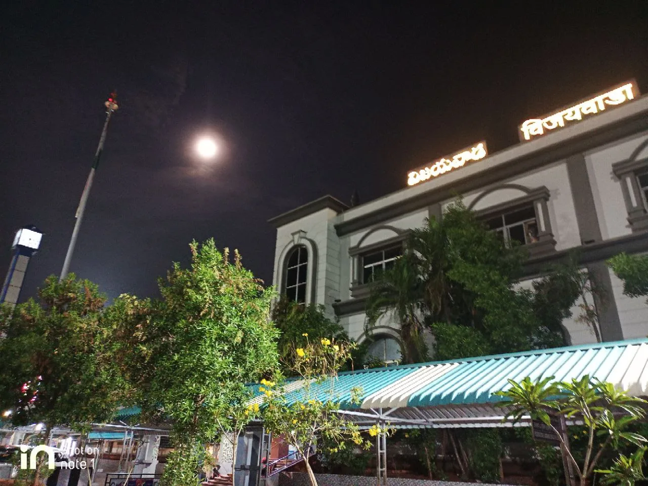 C Sarath Babu's writing on the APSCHE award, 2023. Vijayawada railway station lit up at night under a full moon, the night Sarath arrived